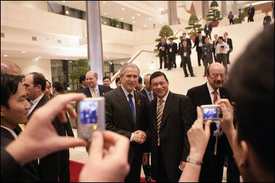President George W. Bush is the focus of onlookers as he departs the National Conference Center Saturday, Nov. 18, 2006, following the first session of the 2006 APEC Summit in Hanoi.