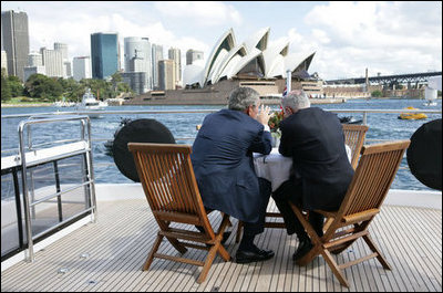 With the Sydney Opera House as a backdrop, President George W. Bush and Prime Minister John Howard of Australia, talk as they tour Sydney Harbor Wednesday, Sept. 5, 2007, aboard the MV AQA.