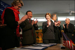 Laura Bush applauds as Secretary of Education Margaret Spellings and Afghan Minister of Education Noor Mohammas Qarqeen complete the signing of the Memorandum of Understanding for funds to build a university in Kabul, Afghanistan, Wednesday, March 30, 2005.