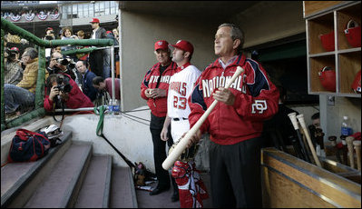 President George W. Bush looks towards the field as he stands in the dugout Thursday, April 14, 2005.  The President's appearance highlighted the celebration that marked the return of major league baseball to Washington with the arrival of the Washington Nationals.