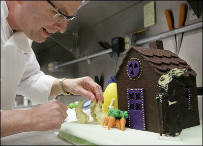 White House pastry chef Bill Yosses, carefully places white chocolate rabbits on a section of the chocolate egg village Friday, March 21, 2008 in the White House pastry kitchen, prepared for Monday's 2008 White House Easter Egg Roll.