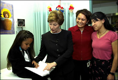 While promoting her <EM>Reach Out and Read</EM> program, Laura Bush reads to a child at the Kayenta Indian Health Service Clinic in Kayenta, Ariz., May 8, 2003.