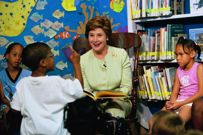 Laura Bush listens to a child's reaction to her reading of 
