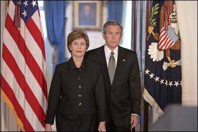 President George W. Bush and Mrs. Laura Bush walk into the Cross Hall prior to the President giving remarks on the death of Pope John Paul II at the White House on Saturday April 2, 2005.