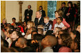 President George W. Bush and Laura Bush sit with children, Monday, Dec. 5, 2005 at the White House, as they watch a dance performance during the White House Children's Holiday Reception in the East Room.