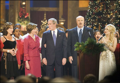 President and Mrs. Bush sing "Hark, the Herald Angels Sing!" along with Dr. Phil McGraw, his wife Robin, left, and Carrie Underwood, right, during the 24th Annual Christmas in Washington at the National Building Museum in downtown Washington D.C.