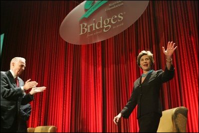 Laura Bush acknowledges the applause of the crowd as she is introduced at the Marriott Foundation for Disabilities Gala Dinner, June 14, 2005 at the Marriott Wardman Park Hotel in Washington, D.C. J.W. (Bill) Marriott, Jr., left, is seen welcoming Mrs. Bush to the podium.