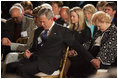 President George W. Bush and Laura Bush holds hands with guests while praying during a ceremony observing the National Day of Prayer in the East Room Thursday, May 5, 2005.