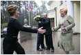President George W. Bush and Russia President Vladimir Putin embrace in the background as Mrs. Bush reaches out to Lyudmila Putina, Russia's first lady, as the Bushes arrived Sunday, May 8, 2005, at the Putin residence shortly after their arrival in Moscow.