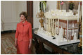 Laura Bush stands before the White House gingerbread house , Wednesday, Nov. 30, 2005, as she answers questions during the press preview of the White House Christmas decorations.