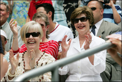 Mrs. Laura Bush and Lynne Pace, wife of General Peter Pace, front-left, applaud the Little League players taking the field at the opening Tee Ball game of the 2006 season on the South Lawn of the White House, Friday, June 23, 2006. General Pace was the Tee Ball Commissioner for the game.