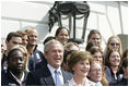 President George W. Bush and Laura Bush, seen holding an Olympic torch, pose with the 2006 U.S. Winter Olympic and Paralympic teams during a congratulatory ceremony held on the South Lawn at the White House Wednesday, May 17, 2006.