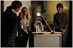 Mrs. Laura Bush watches as David Temple, actor portraying Benjamin Franklin, performs a demonstration related to static electricity at the Houston Museum of Natural Science, Wednesday, October 18, 2006, with the help of a 6th grade student from the Baines Middle School in Houston, TX.