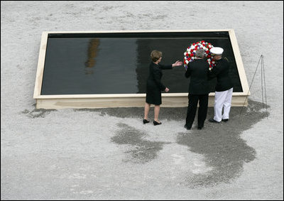 After laying a wreath in the north tower reflecting pool, President George W. Bush and Laura Bush walk through the World Trade Center site to lay a second wreath in the south tower reflecting pool to commemorate the fifth anniversary of the September 11th terrorist attacks in New York City Sunday, September 10, 2006.