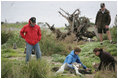 Mrs. Laura Bush works with wildlife biologist John Klavitter to restore native bunchgrass during a tour of Eastern Island on Midway Atoll Thursday, March 1, 2007. Interior Secretary Dirk Kempthorne is pictured in a red jacket.