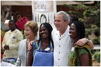 President George W. Bush and Mrs. Laura Bush pose for a photo with two women Wednesday, Feb. 20, 2008, during his visit to the International Trade Fair Center in Accra, Ghana.
