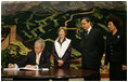 President George W. Bush signs his condolences for the victims of China's May 12, earthquake as he and Mrs. Laura Bush visit the Embassy of the People's Republic of China Tuesday, May 20, 2008, in Washington, D.C. With them are China's Ambassador to the United States Wenzhong Zhou and his spouse, Shumin Xie.