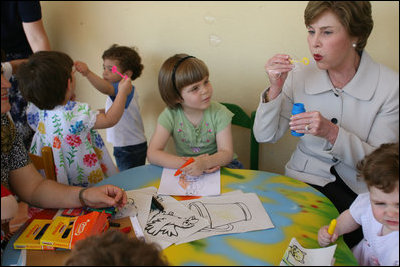 Mrs. Laura Bush blows bubbles for youngsters at the Bethany House Orphanage Sunday, June 10, 2007, in Tirana, Albania. The orphanage is overseen by Bethany Christian Services in Michigan, and has been active in Albania since 1991.