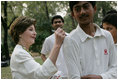 Mrs. Laura Bush signs the team jerseys of the Islamabad College of Boys cricket team, who participated in a cricket clinic with President George W. Bush, Saturday, March 4, 2006 at the Raphel Memorial Gardens on the grounds of the U.S. Embassy in Islamabad, Pakistan.