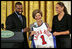 Golden State Warrior Baron Davis, left, and Phoenix Mercury guard Diana Taurasi, right, present Laura Bush with a basketball jersey at the National Book Festival Author's breakfast in the East Room Saturday, Sept. 24, 2005.