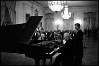 Former President Harry Truman tickles the ivories for President and Mrs. Kennedy in the East Room November 1, 1961.