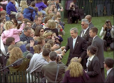 President George W. Bush greets an enthusiastic crowd of visitors on the South Lawn, April 1, 2002, during the White House Easter Egg Roll.
