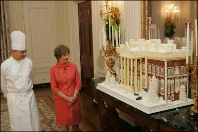 Laura Bush is shown the White House gingerbread house by White House pastry chef Thaddeus DuBois, on display in the State Dining Room.