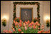 In the State Dining Room, President Lincoln’s portrait is framed by tulips and Boxwood Garland.