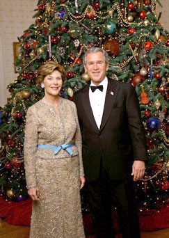 President George W. Bush and Laura Bush stand in front of the official White House Christmas Tree during the 2004 holiday season in the Blue Room of the White House. The White House celebrates the holidays with, A Season Of Merriment and Melody, and include items like 350 instrument ornaments that adorn the Blue Room tree. 