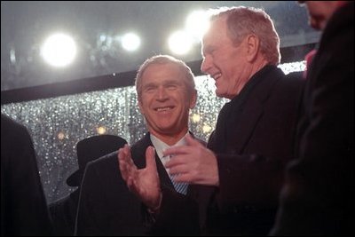 President George W. Bush talks with his father, former President George H.W. Bush during the Inaugural Parade in Washington, D.C., Jan. 20, 2001.