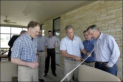 President Bush looks over economic data with his team of economic advisors during a session of meetings at his Texas ranch Aug. 13, 2003. .We believe strongly that the tax relief plan that was approved by Congress in '01, and most recently in '03, is going to have a very positive effect on economic growth and vitality,. said the President in his remarks to the press about the meetings.