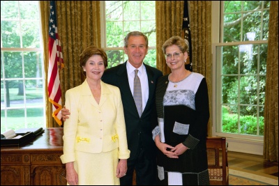 President George W. Bush and Laura Bush congratulate 2003 Maine Teacher of the Year Carol T. Hines in the Oval Office Wednesday, April 30, 2003. White House Photo by Eric Draper