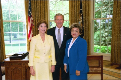 President George W. Bush and Laura Bush congratulate 2003 Maine Teacher of the Year Virginia Avila in the Oval Office Wednesday, April 30, 2003. White House Photo by Eric Draper