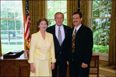 President George W. Bush and Laura Bush congratulate 2003 Maine Teacher of the Year Rich Mayorga in the Oval Office Wednesday, April 30, 2003. White House Photo by Eric Draper