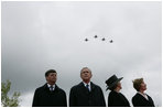 Jan Peter Balkenende, Prime Minister of The Netherlands, left, President George W. Bush, Queen Beatrix of The Netherlands, and Mrs. Laura Bush stand on stage Sunday, May 8, 2005, at the Netherlands American Cemetery in Margraten, as a flyover marks the remembrance of those who served in World War II.