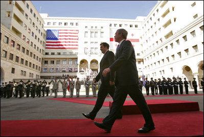 President George W. Bush walks with President Mikhail Saakashvili during an arrival ceremony in the courtyard of the Parliament Building in Tbilisi, Georgia, Tuesday, May 10, 2005.