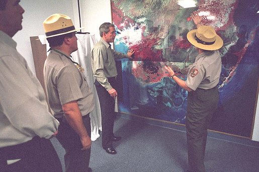 President George W. Bush looks over a topography map with national park service officer upon arriving at the Royal Palm Visitors Center at Everglades National Park, Fla., June 4, 2001. White House photo by Eric Draper.