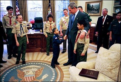 President Bush accepts the annual Report to the Nation by representatives of the Boy Scouts of America in the Oval Office March 2, 2004. On that same day a program was announced that will soon allow Iraqi children to participate in an Iraqi Boy Scout and Girl Scout program. The history of scouting in Iraq dates back to 1921, but all programs were terminated in the Saddam Hussein era. The initiative is backed by the World Scouting Organization, the Arab Scout Organization and about 100 former scouters now serving in Iraq. 