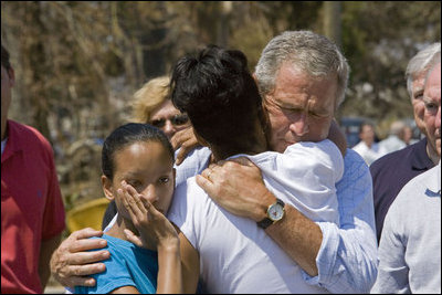 President George W. Bush comforts Bronwynne Bassier, right, and her sister Kim after landing in Biloxi, Miss., Friday Sept. 2, 2005, as part of his tour of the Hurricane Katrina-ravaged Gulf Coast. Their family lost everything in the wake of the devastating storm.