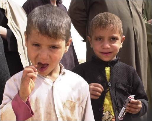 The children's of a local Iraqi family in the community enjoy a tootsie roll.