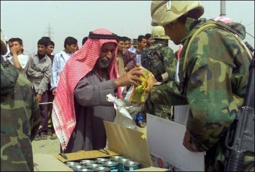 Marines from TF Tarawa hand out needed food and supplies to Iraqi citizens near An Nasariyah, Iraq.