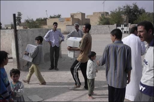 Local Basra residents help Special Operation Civil Affairs Soldiers unload school supplies in Iraq, April 4, 2003. The school supplies, stockpiled with other humanitarian aid materials by the Saddam Hussein regime are now finding their way to their originally intended destinations. (U.S. Army photo by Spc. Thomas Mund).