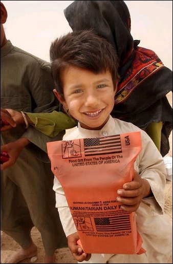 An Iraqi boy holds a humanitarian food ration given to him by U.S. Army soldiers during an effort to distribute food and water to Iraqi citizens in need.