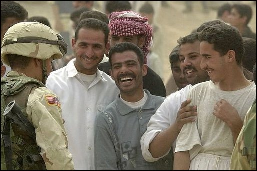 Iraqis share a laugh with a U.S. Army Specialist Michael Toro during an effort to distribute food and water to Iraqi citizens in need.