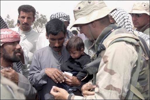 Navy Doctor Lieutenant Charles Presenza from MWSS-271, gives medical advice to Iraqis on April 8, 2003. Corpsman from MWSS-271 visited a farm village near Three Rivers as part of humanitarian aid in support of Operation Iraqi Freedom. 