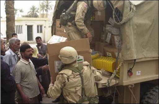 Soldiers from 30th Medical Brigade of Heidberg, Germany, and Iraqi civilians work together to unload a truck of medical supplies for Baghdad Childrens Hospital, April 15, 2003. The 30th Medical Brigade is deployed in support of Operation Iraqi Freedom.