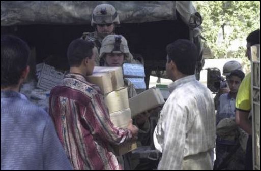 British soldiers distribute water to an Iraqi farmhouse in southern Iraq, April 1, 2003. (U.S. Army photo by Capt. Deborah Molnar.) 