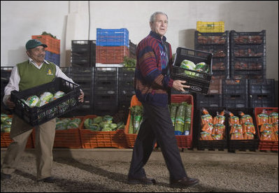 President George W. Bush lends a hand loading crates of lettuce Monday, March 12, 2007, during a visit to the Labradores Mayas Packing Station in Chirijuyu, Guatemala. White House photo by Paul Morse