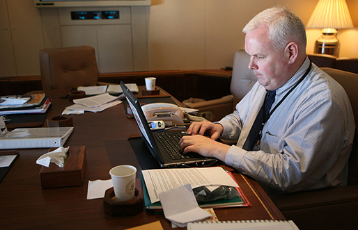 Bill McGurn, Assistant to the President for Speechwriting, works on his laptop aboard Air Force One Sunday, Jan. 13, 2008. White House photo by Eric Draper 