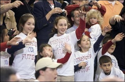Wearing matching of T-shirts, a group of future retirees wave during the President's visit to Shreveport, La., Friday, March 11, 2005.
